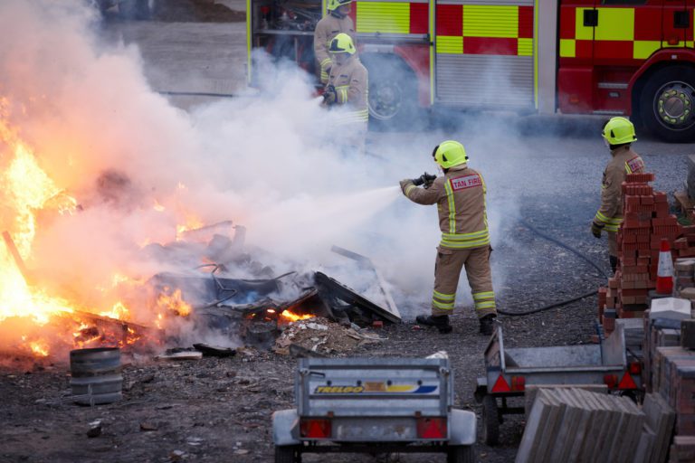 Firemen attending to blazing bonfire
