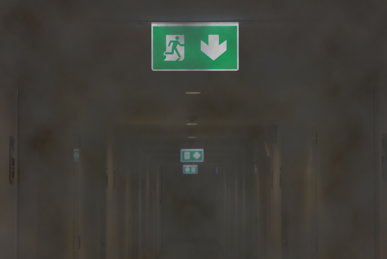 Fire Exit Light in Smoky Corridor of Apartment
