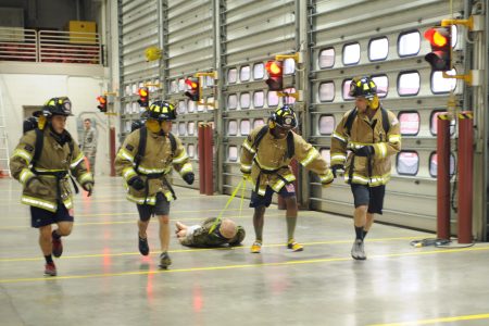 Airmen participate in a dummy drag obstacle as a part of the Firefighter Challenge at Ellsworth Air Force Base, S.D., Oct. 2, 2015. The rescue dummy weighed approximately 200 pounds and simulated rescuing an unconscious smoke inhalation victim. (U.S. Air Force photo by Airman Sadie Colbert/Released)